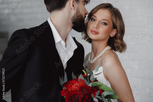 Portrait Romantic Happy Couple, Young Man Sharing Moment With Woman Bride Holding Red Bouquet. Modern Wedding Day Concept