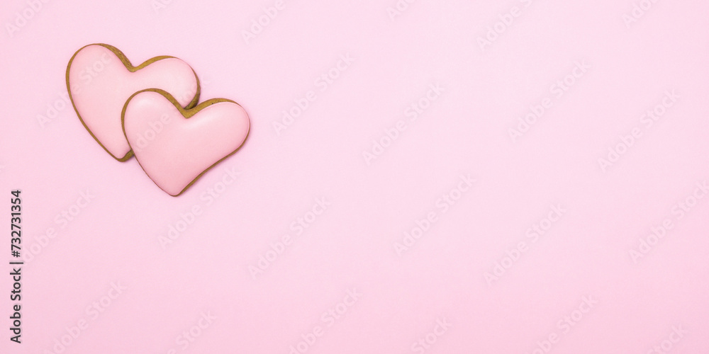 Two heart-shaped cookie with icing on pink background. Valentine's day.