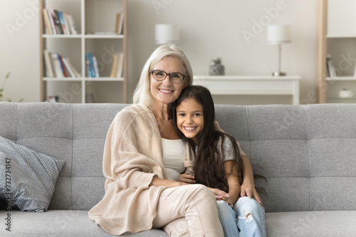 Vászonkép Happy positive loving granny and cute granddaughter girl hugging with love, affe