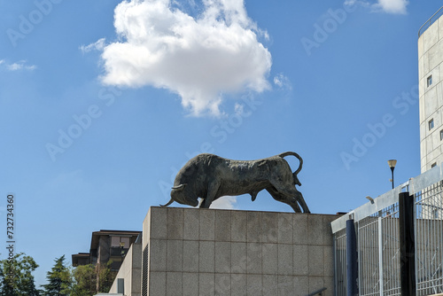 Statue of a bull against a blue sky on the facade of the building of bullring. The bull is an iconic symbol of Spain photo