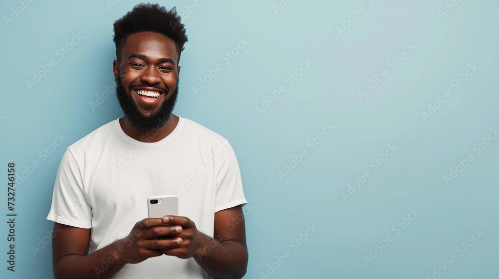 Black man holding a cellphone against a blue background Black man holding a cellphone against a blue background