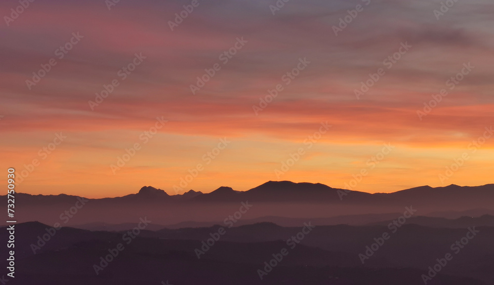 Il cielo rosso di nuvole sopra le montagne al tramonto