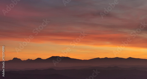 Il cielo rosso di nuvole sopra le montagne al tramonto