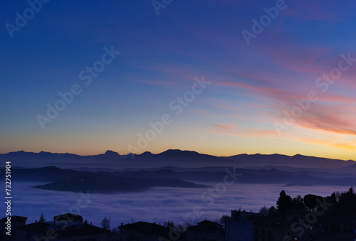 Le valli tra monti si riempiono al tramonto di un mare di nuvole photo