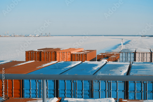 Container Ship Sailing Underway In The Frozen International Shipping Fairway Route. Water Surface Covered With Ice. Winter Navigation in The Arctic Area Region photo