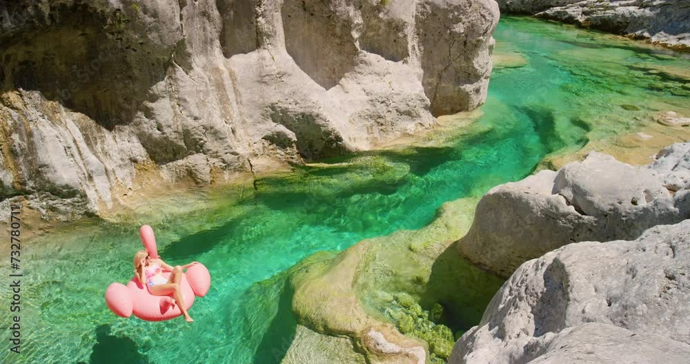 Woman, float and lake with inflatable on mountain in Tuscany or holiday adventure at tropical island, paradise or relax. Female person, flamingo lilo and water in natural rock pool, travel or summer