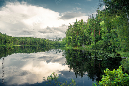 Big clouds by a forest lake in Sweden