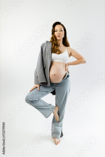 Pregnant girl posing on a white background