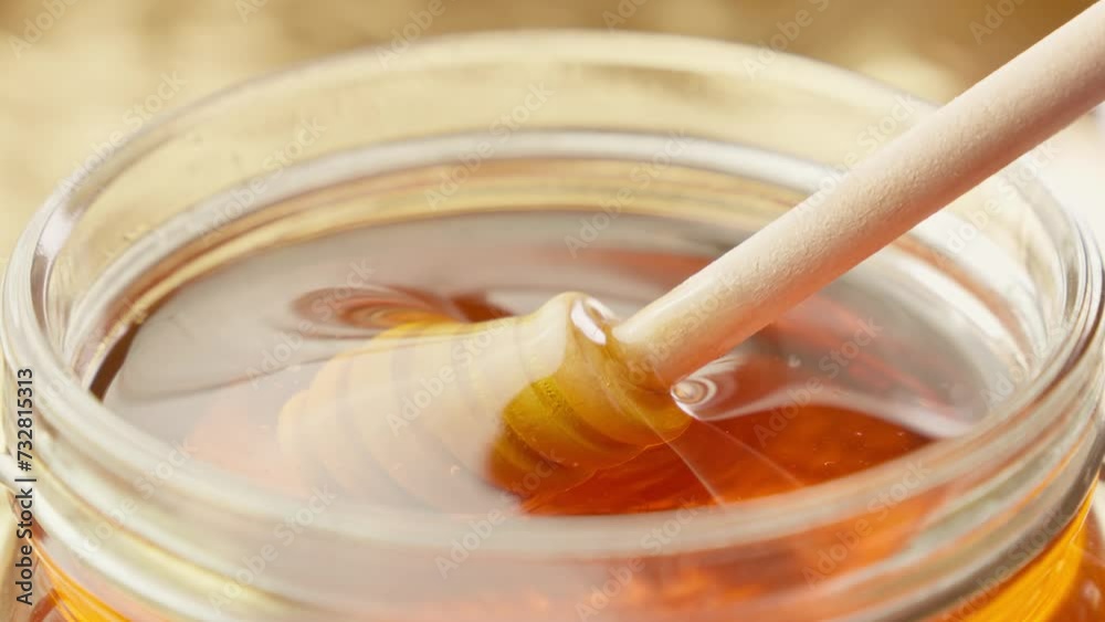 Honey dripping. Dipping honey with honey scoop in glass jar. Healthy organic food. Thick honey dripping from wooden spoon. Close-up in 4K, UHD Honey dripping. Dipping honey with honey scoop in glass jar. Healthy organic food. Thick honey dripping from wooden spoon. Close-up in 4K, UHD