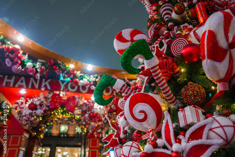 A festive Christmas display in London featuring traditional red, green, and white decorations, including candy canes, baubles, and a garland with a THANK YOU sign, illuminated against a night sky.