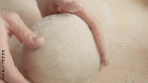 Bakery worker carefully forming loaf of bread. Male hands kneading dough in flour on table. Bread production. Bakery concept. Close-up in 4K, UHD