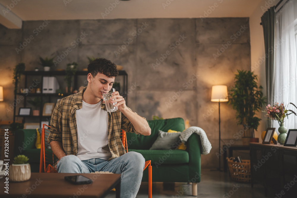 man young caucasian male teenager hold glass of water at home