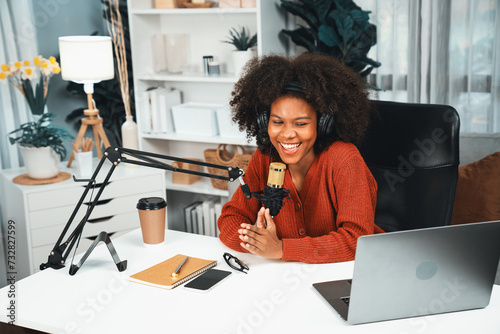 Host channel of beautiful African woman talking in online broadcast teaching marketing influencer, with listeners in broadcast or online. Concept of anywhere at work place. Tastemaker. photo