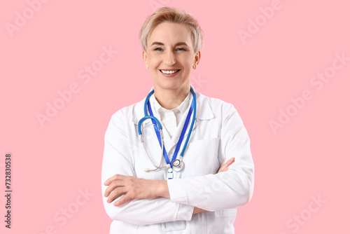 Mature female doctor on pink background