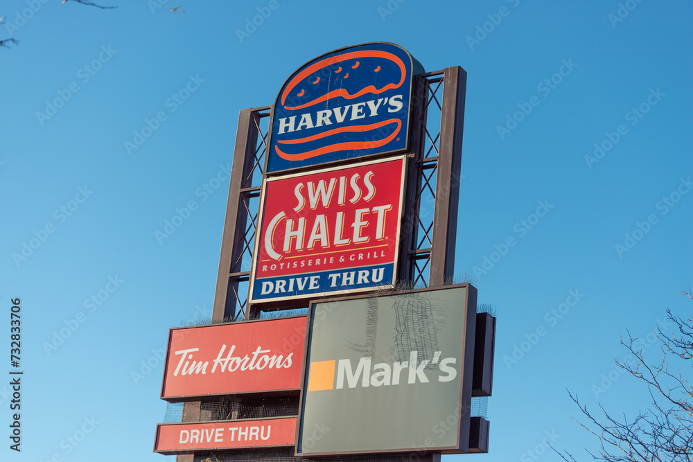 exterior pylon sign featuring Harvey's, Swiss Chalet, Tim Hortons, and