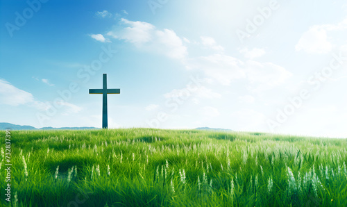 The Cross of Christ in a Green Field on a Sunny Day with White Clouds in the SKy