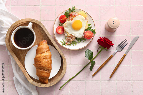 Composition with tasty fried egg in plate  croissant and cup of coffee on light tile background