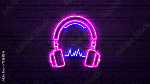 Neon bright headphones with a shadow on the background of a brick wall in blue and pink.