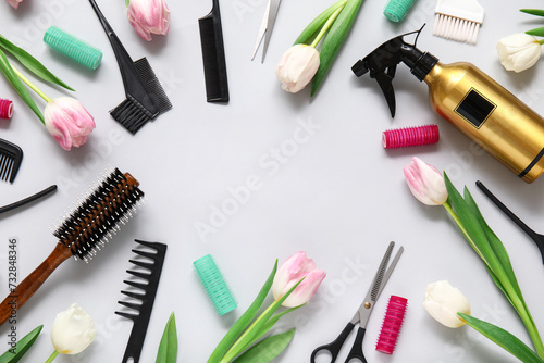 Frame made of hairdresser's tools with beautiful tulips on grey background