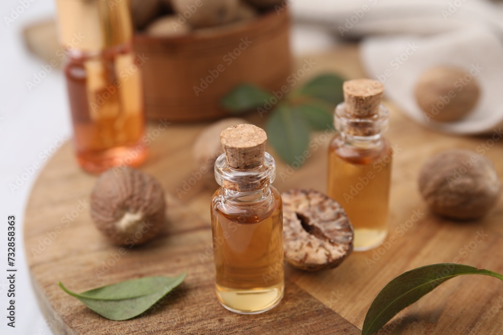 Nutmeg essential oil and nuts on table Nutmeg essential oil and nuts on table