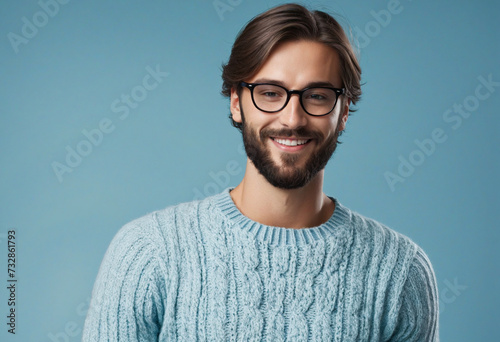 Young handsome man with beard wearing casual sweater and glasses over blue background