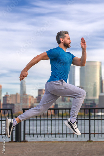 Man runner in sport outfit run in NYC. Motion, healthy run. Jogger run near Manhattan downtown. Muscular athlete sportsman run in city. Running sportswear. Handsome guy running workout outdoor.