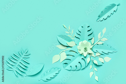 Beautiful paper flowers and leaves on green background