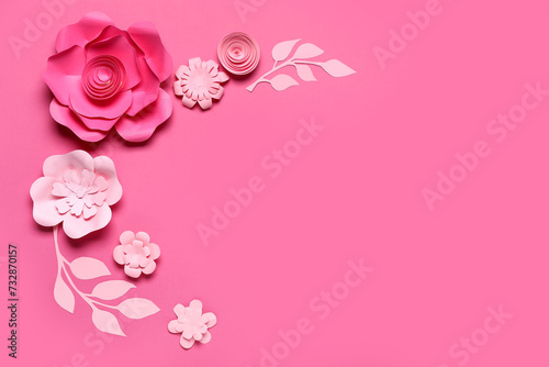 Frame made of beautiful origami flowers with leaves on pink background