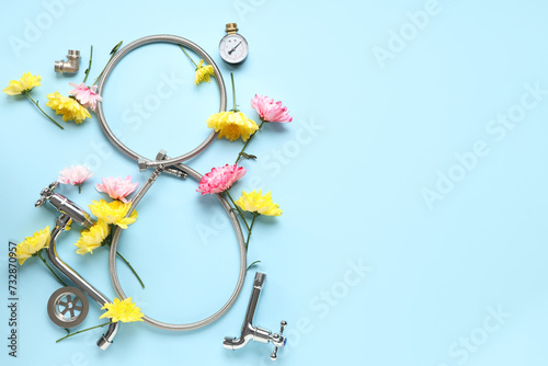 Composition with figure 8 made of flexible hose, plumber's items and flowers on color background. International Women's Day photo