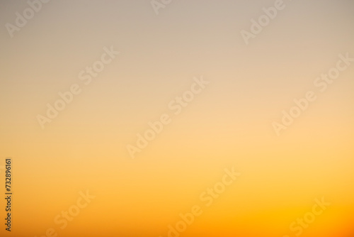 Abstract defocused shot of the sky during sunset hours casting a deep orange light