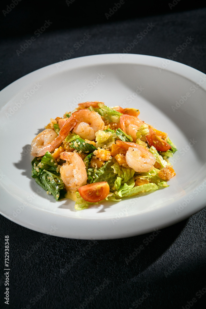 Shrimp salad with quinoa and mixed greens closeup, garnished with cherry tomatoes and a light dressing Shrimp salad with quinoa and mixed greens closeup, garnished with cherry tomatoes and a light dressing