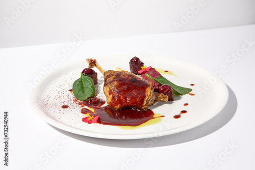 Duck leg confit with berry sauce, artistically presented on an isolated white background, a feast for the senses