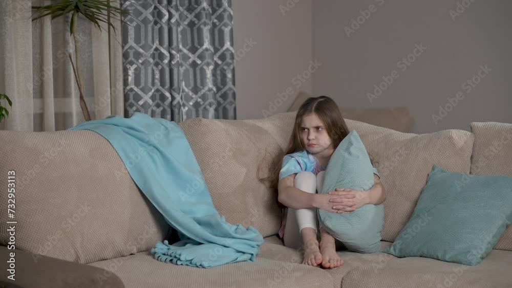 Offended kid sitting on couch. Upset unhappy cute girl feeling sad. Children problem, conflict concept. Alone bullied abused abandoned child stressed sitting on sofa at home Offended kid sitting on couch. Upset unhappy cute girl feeling sad. Children problem, conflict concept. Alone bullied abused abandoned child stressed sitting on sofa at home
