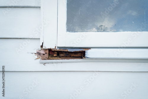 Rotten wooden window frame in an old house. © Janice