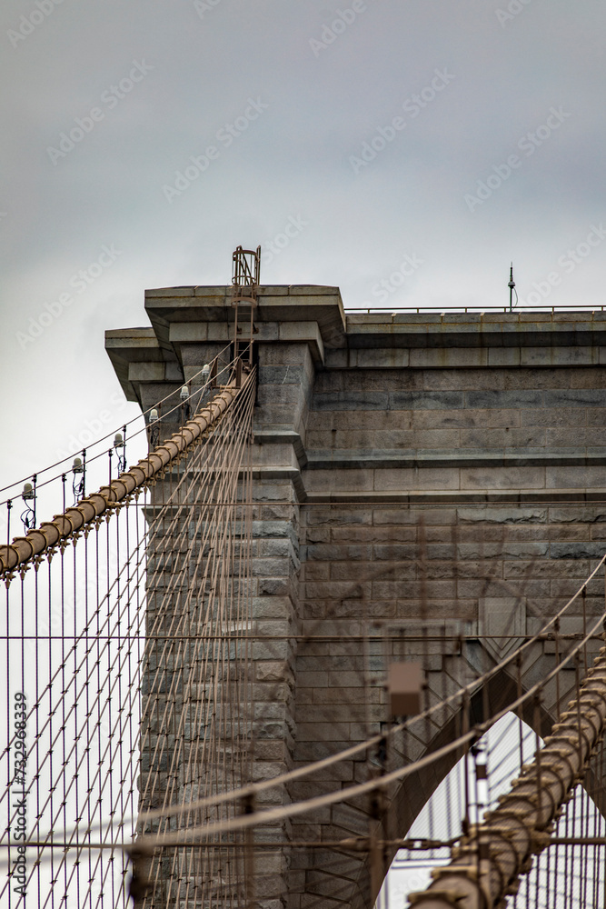 Fototapeta premium Upper left side of the Brooklyn Bridge linking the boroughs of Manhattan and Brooklyn in New York City (USA). It was the largest suspension bridge in the world, record span until 1889.