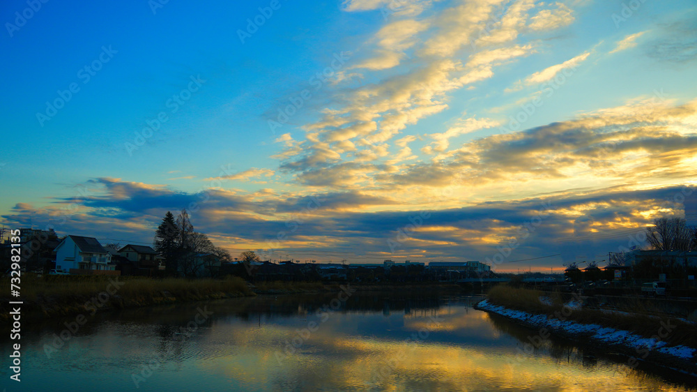 川の朝焼けと壮大な雲。雲から漏れる暖かい陽射しの絶景風景