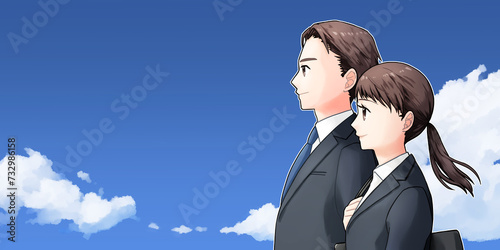 スーツ姿の若い男女　横向き上半身　青空背景