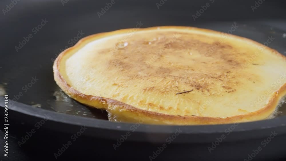 Baking pancakes at home. An American pancake is baked in a black pan. 4k Slow motion video, 100fps. Baking pancakes at home. An American pancake is baked in a black pan. 4k Slow motion video, 100fps.