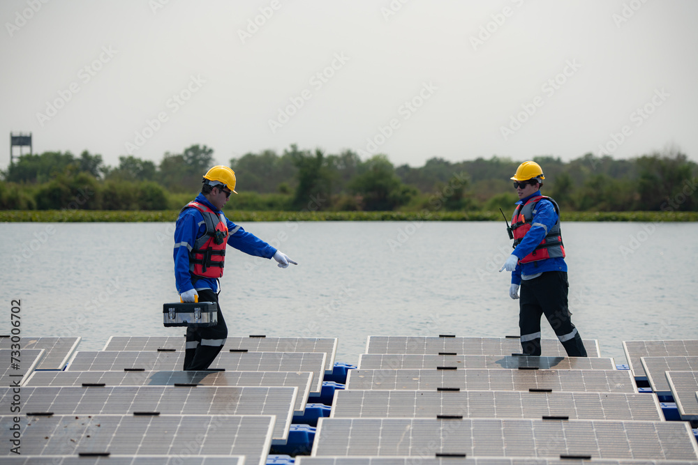 Photovoltaic engineers work on floating photovoltaics. Inspect and repair the solar panel equipment floating on the water.