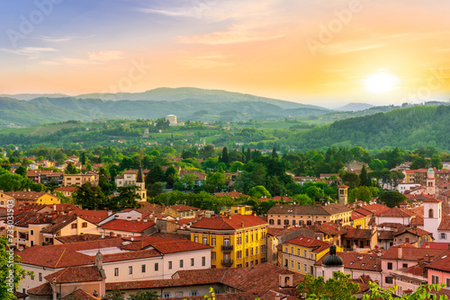 travel summer view from hill to a nice european town with amazing buildings, green hills and mountains with amazing cloudy evening sky on background © Yaroslav