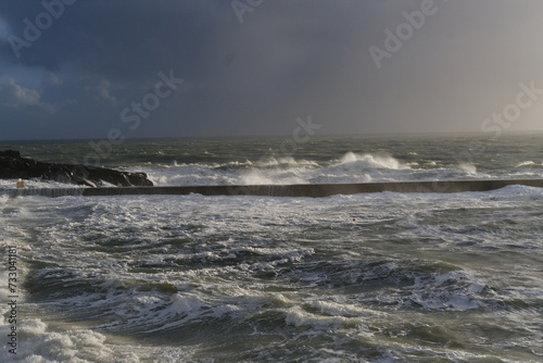 A view of the jetty of a small French harbor on a stormy day. Batz-sur-Mer, France - February 10, 2024. © Yann Vernerie