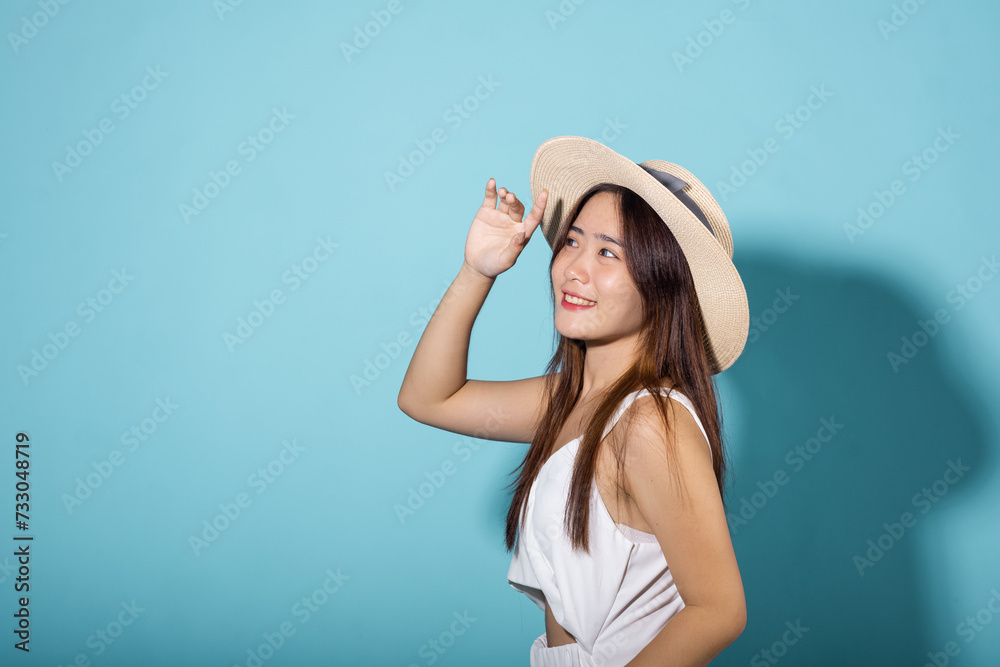Female raising arm and hand in protection and block sunshine in studio shot isolated on blue background, Asian young woman smile hand up cover face protect sun light and UV, sunscreen cream advertise Female raising arm and hand in protection and block sunshine in studio shot isolated on blue background, Asian young woman smile hand up cover face protect sun light and UV, sunscreen cream advertise