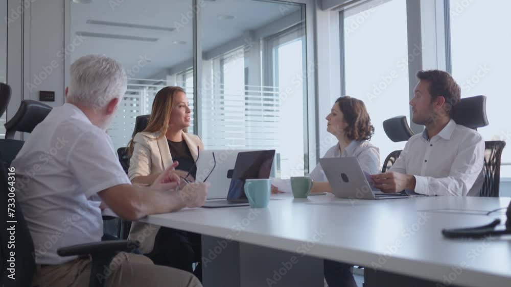 Business workers team smiling and engaging in communication in meeting. Group of professionals having discussion in modern office conference room