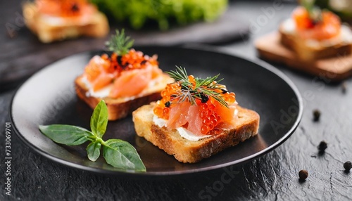 closeup of appetizers toast with salmon and lumpfish roe in a black plate photo