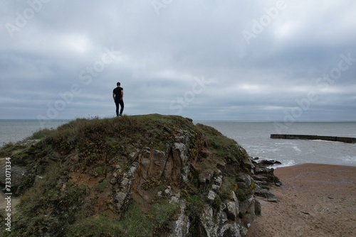 Model photo sur les rochers d'une plage francaise, vue aérienne en drone