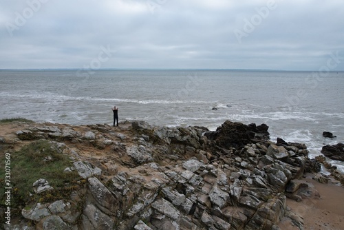 Model photo sur les rochers d'une plage francaise, vue aérienne en drone
