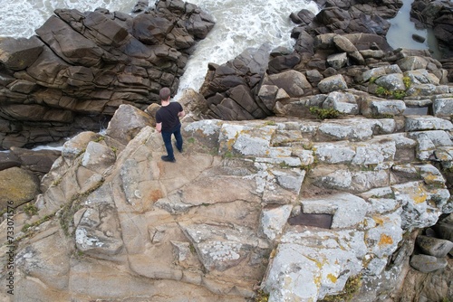 Model photo sur les rochers d'une plage francaise, vue aérienne en drone