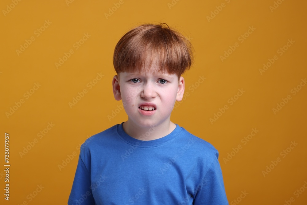 Portrait of surprised little boy on orange background Portrait of surprised little boy on orange background