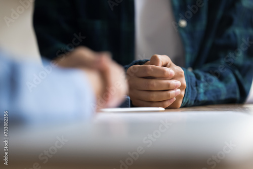 Photos Close up of hands of two young women talking at table