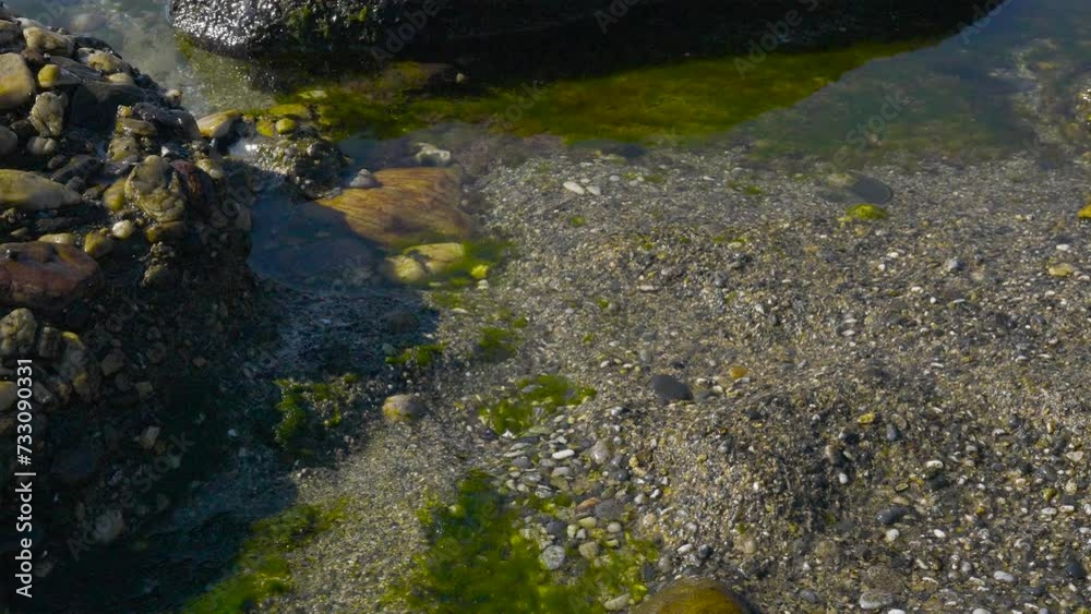Close up of Clear Foamy Sea Waves Flowing into Shore Rock Formation and Beach Close up of Clear Foamy Sea Waves Flowing into Shore Rock Formation and Beach